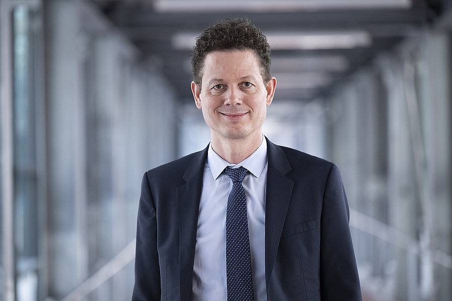 Portaitbild von Christian Lange in einem blauen Anzug