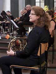 Orchester - imn Vordergrund Musikerin mit Horn